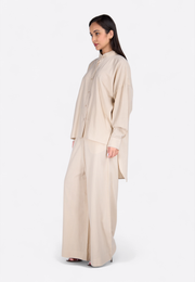 Model wearing tailored beige cotton trousers, front view – East Vibe